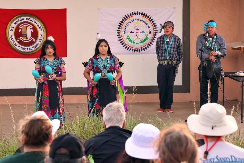 several people in traditional Navajo Regalia dancing on a stage